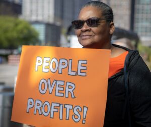 tamara with poeple over profits sign