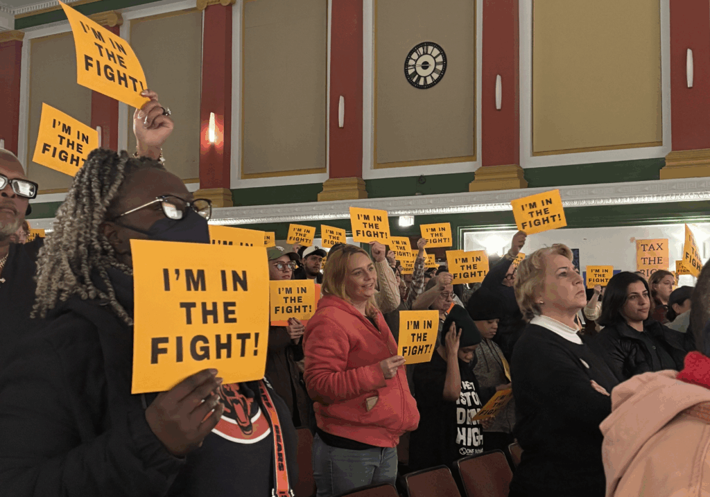 Crowd holding im in the fight signs