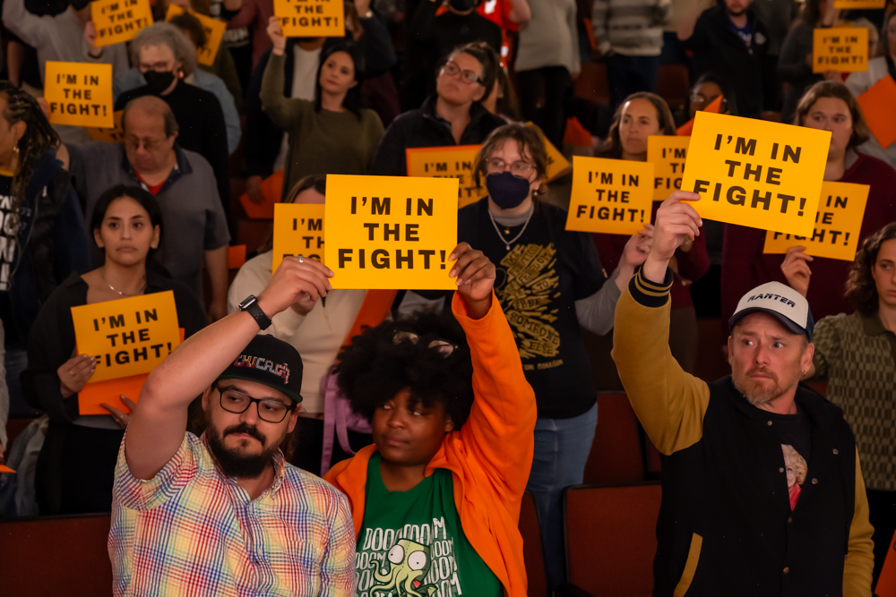 crowd with im in the fight signs