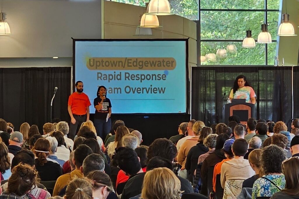 three people presenting in front of a crowd with uptown edgewater rapid response on screen